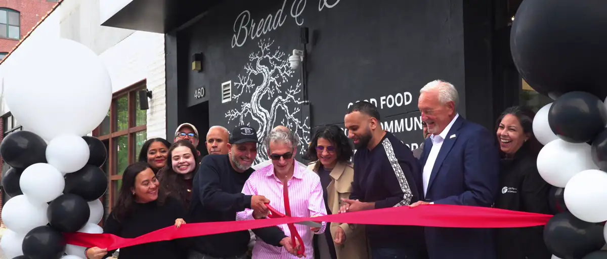 Grand opening ribbon cutting outside Bread & Butter Market at 460 Driggs Avenue
